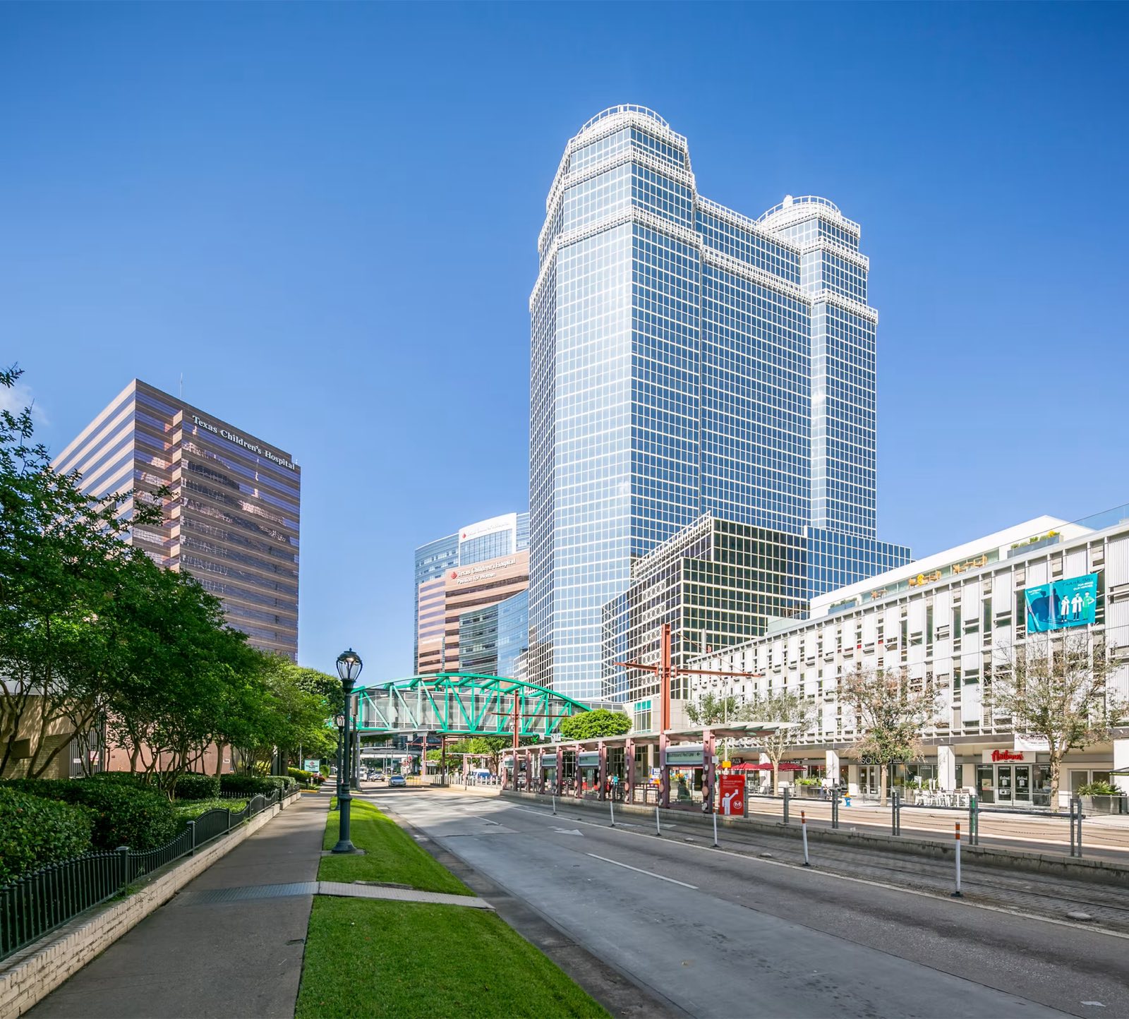 Street-level view of the Advanced Cardiovascular Institute building along Fannin Street with METRORail tracks
